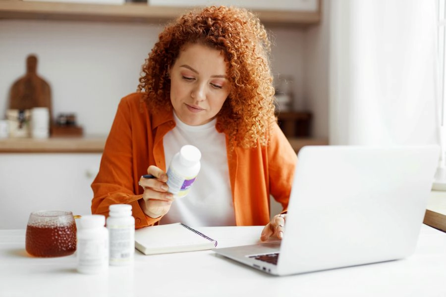 Woman checking a supplement bottle